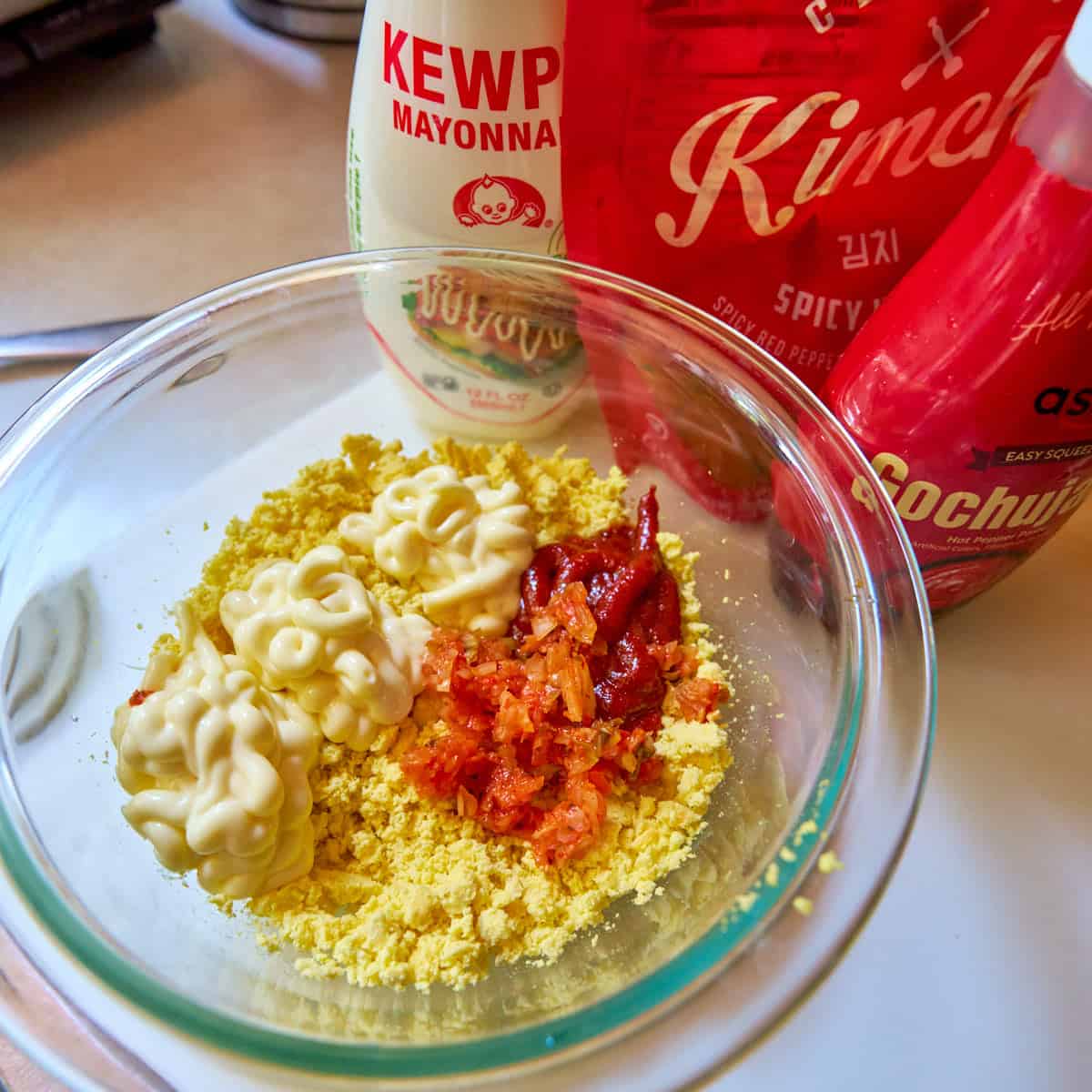 Kimchi deviled eggs fillings- crumbled yolk, kewpie mayo, minced kimchi, and gochujang, ready to mix