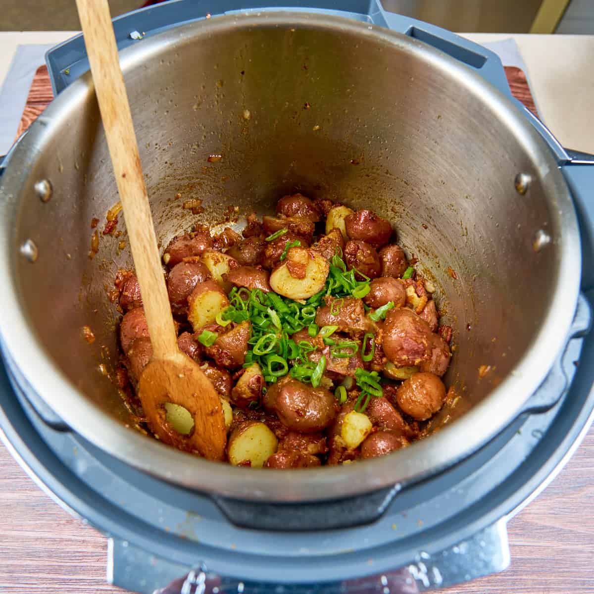 Stirring in the halved cooked potatoes until coated with the bacon vinaigrette