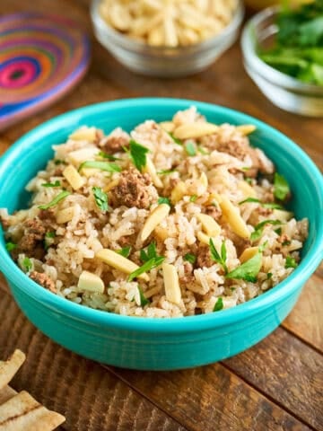 A bowl of Instant Pot Lamb Rice with parsley and almonds