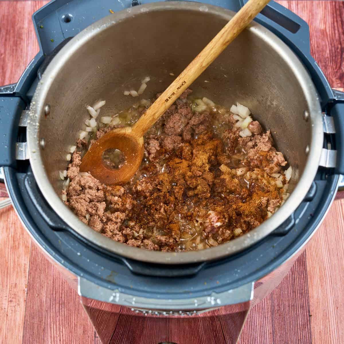Cooking the lamb, spices, and onions in the pot