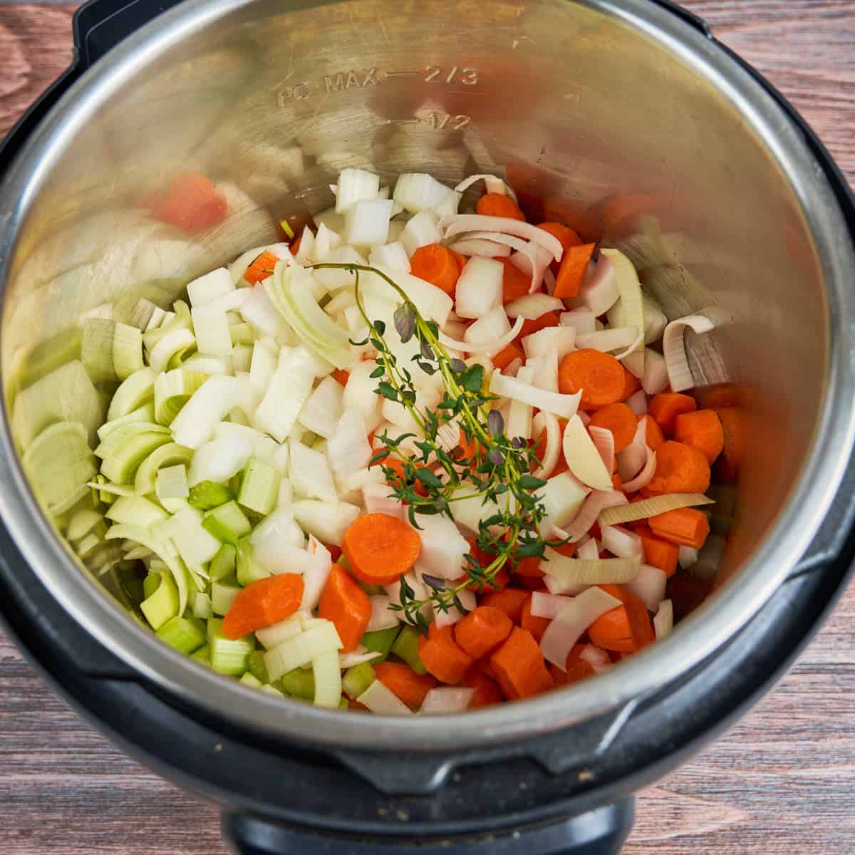 Carrots, celery, leeks, onions, and thyme into the pot.