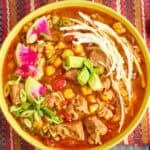 A bowl of Instant Pot Pozole with shredded cabbage, radishes, and avocado