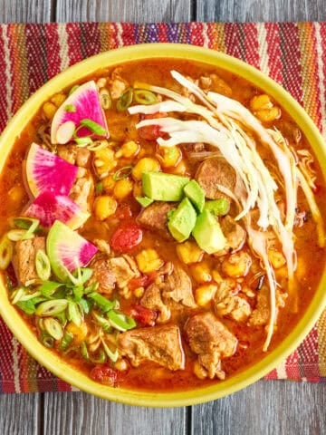 A bowl of Instant Pot Pozole with shredded cabbage, radishes, and avocado