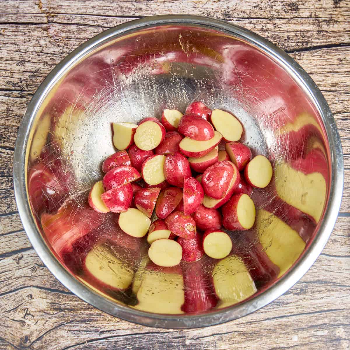 Tossing the halved potatoes with olive oil and salt