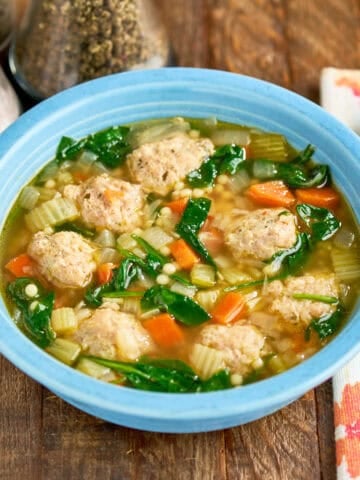 A bowl of Instant Pot Italian Wedding Soup with a spoon and napkin