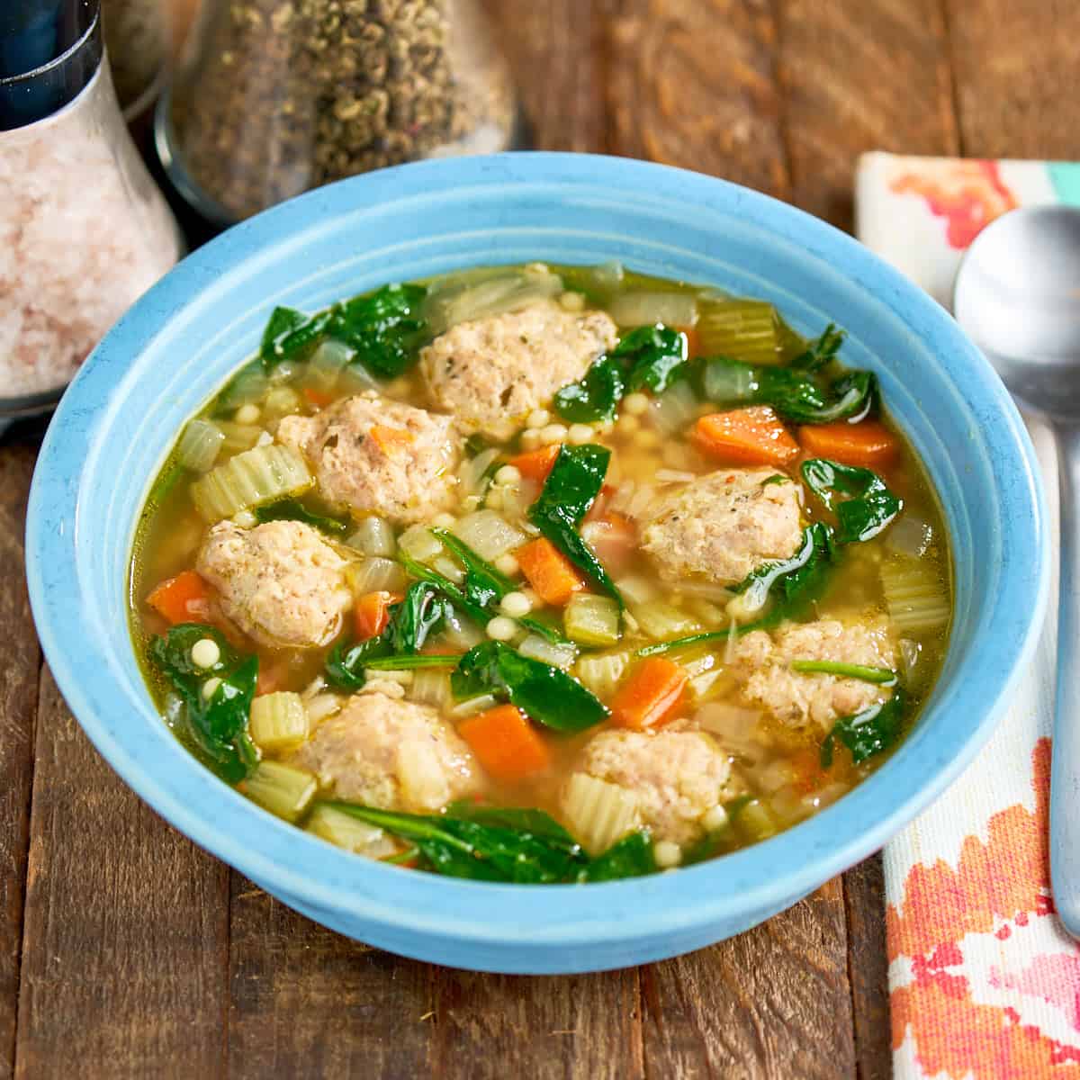A bowl of Instant Pot Italian Wedding Soup with a spoon and napkin