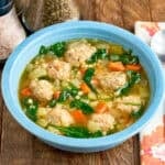 A bowl of Instant Pot Italian Wedding Soup with a spoon and napkin