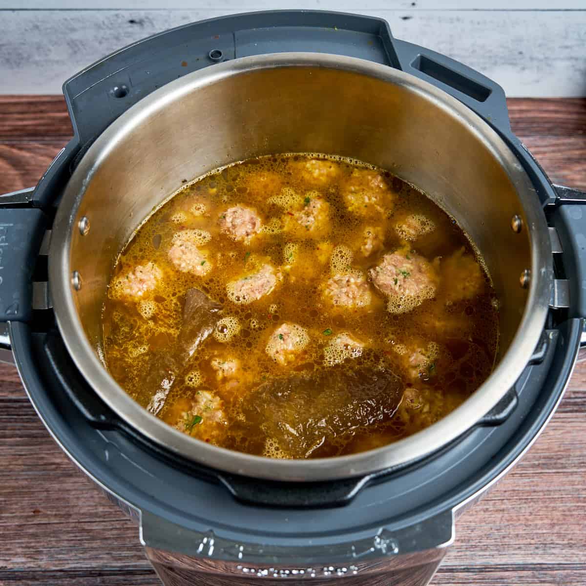 Meatballs and broth and pasta added to the pot