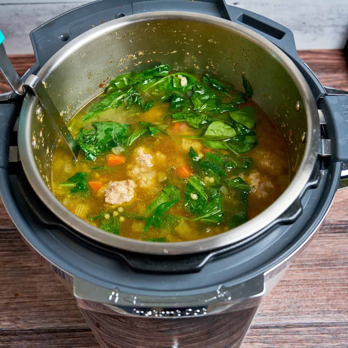 Stirring the spinach into the soup after pressure cooking