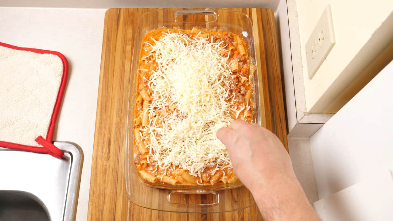 Topping baking dish of ziti with cheese