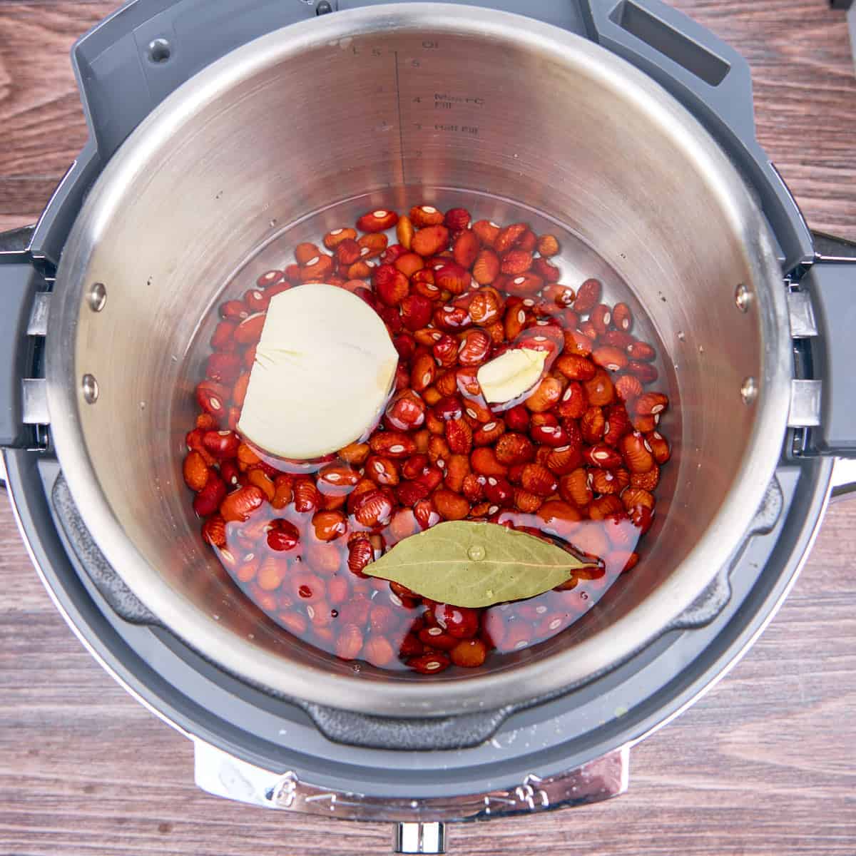 Piloy beans, sorted, rinsed, and in the Instant Pot with water, an onion, garlic, and bay leaf