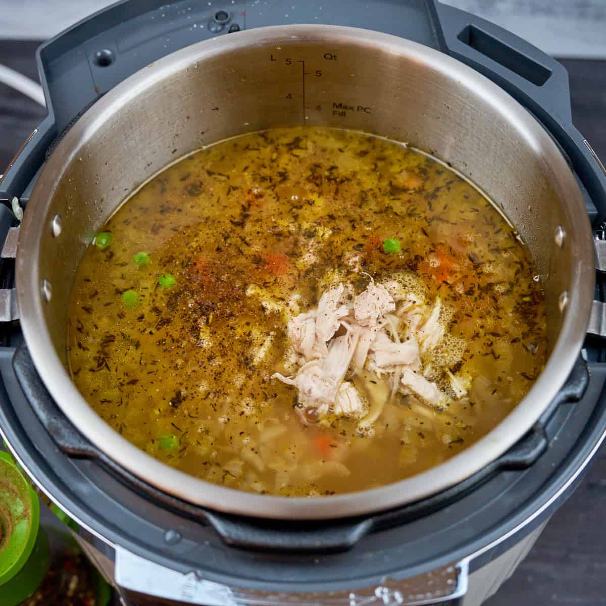 Chicken meat and frozen peas into the cooked soup to reheat