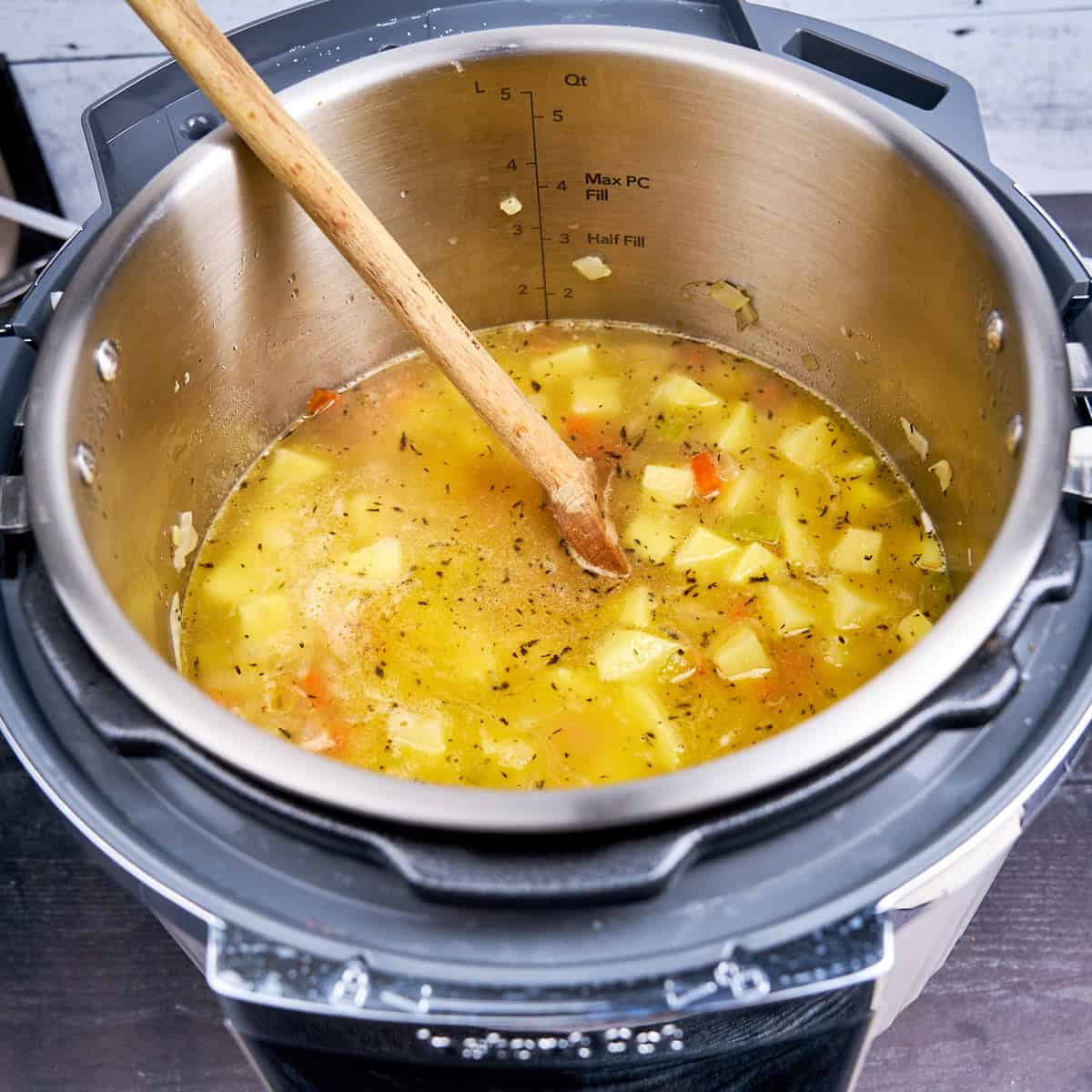 Stirring broth and potatoes into the pot
