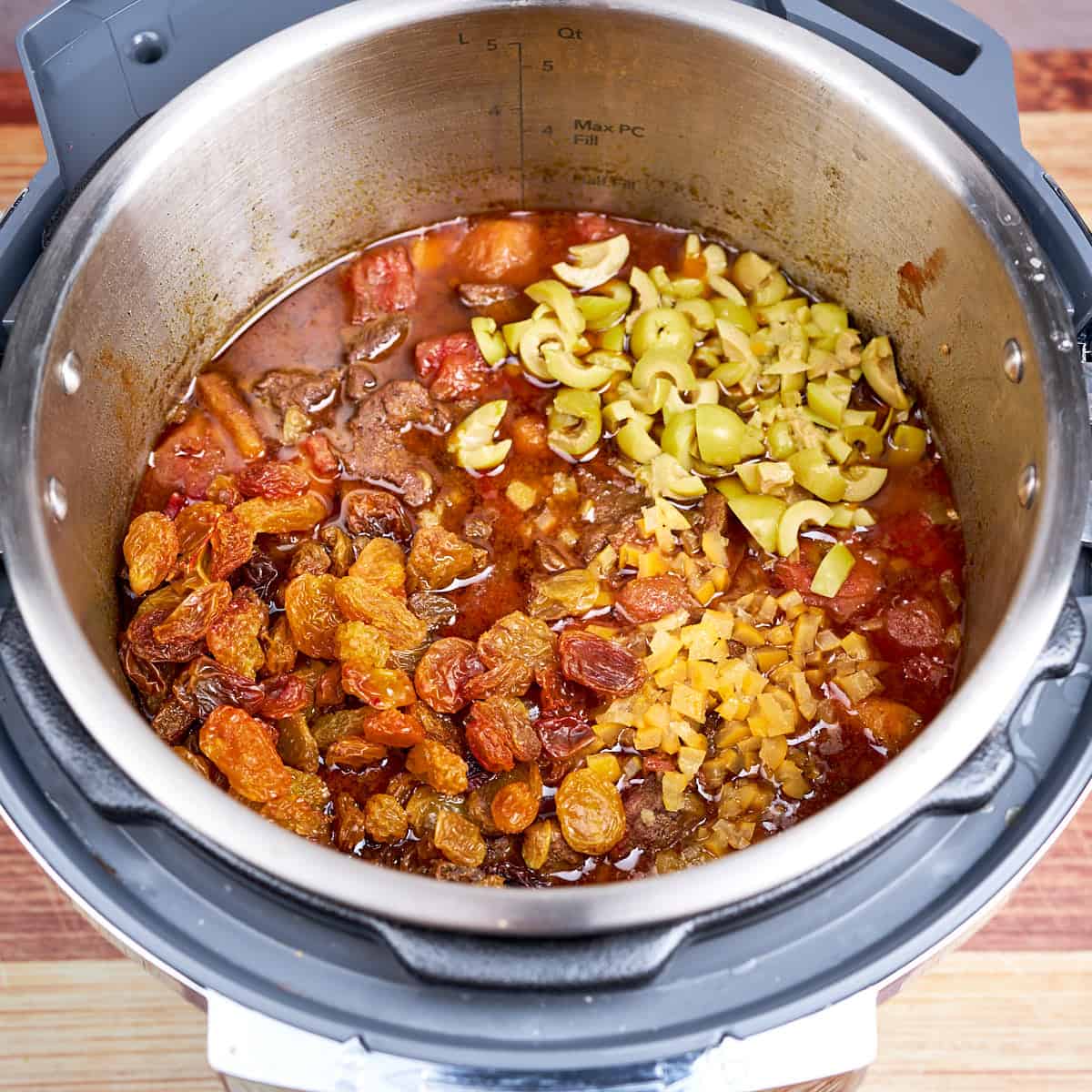 Preserved lemons, raisins and olives into the pot to warm up