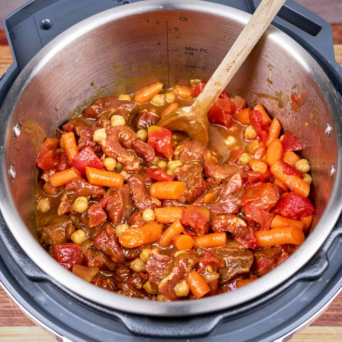 Stir in the broth, marinated lamb, carrots, tomatoes, and chickpeas