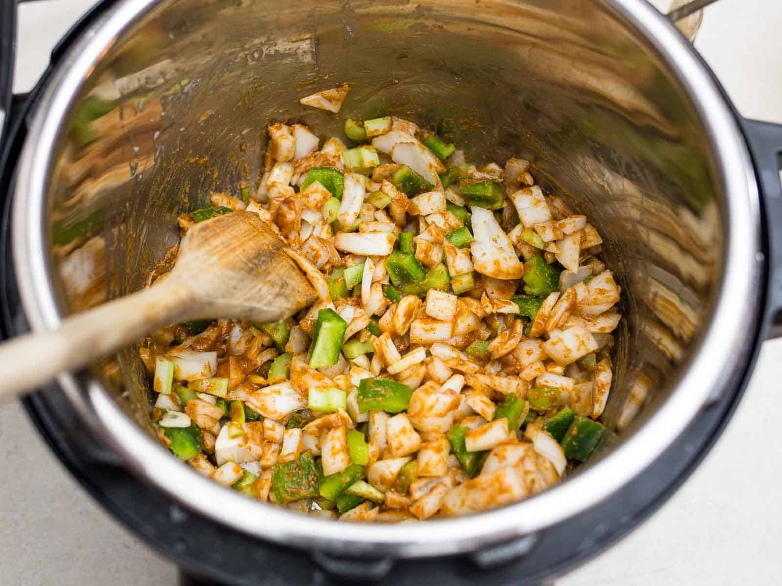 Sauteing the trinity of onion, celery, and bell pepper in the roux