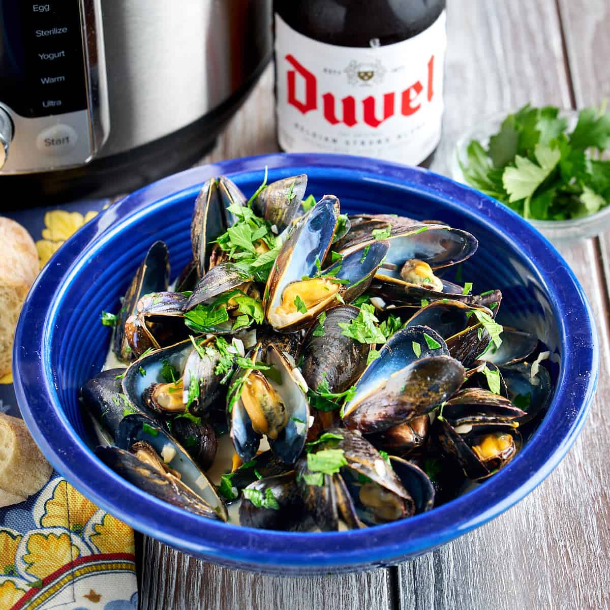 A bowl of Instant Pot Belgian Mussels with a beer