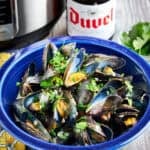 A bowl of Instant Pot Belgian Mussels with a beer