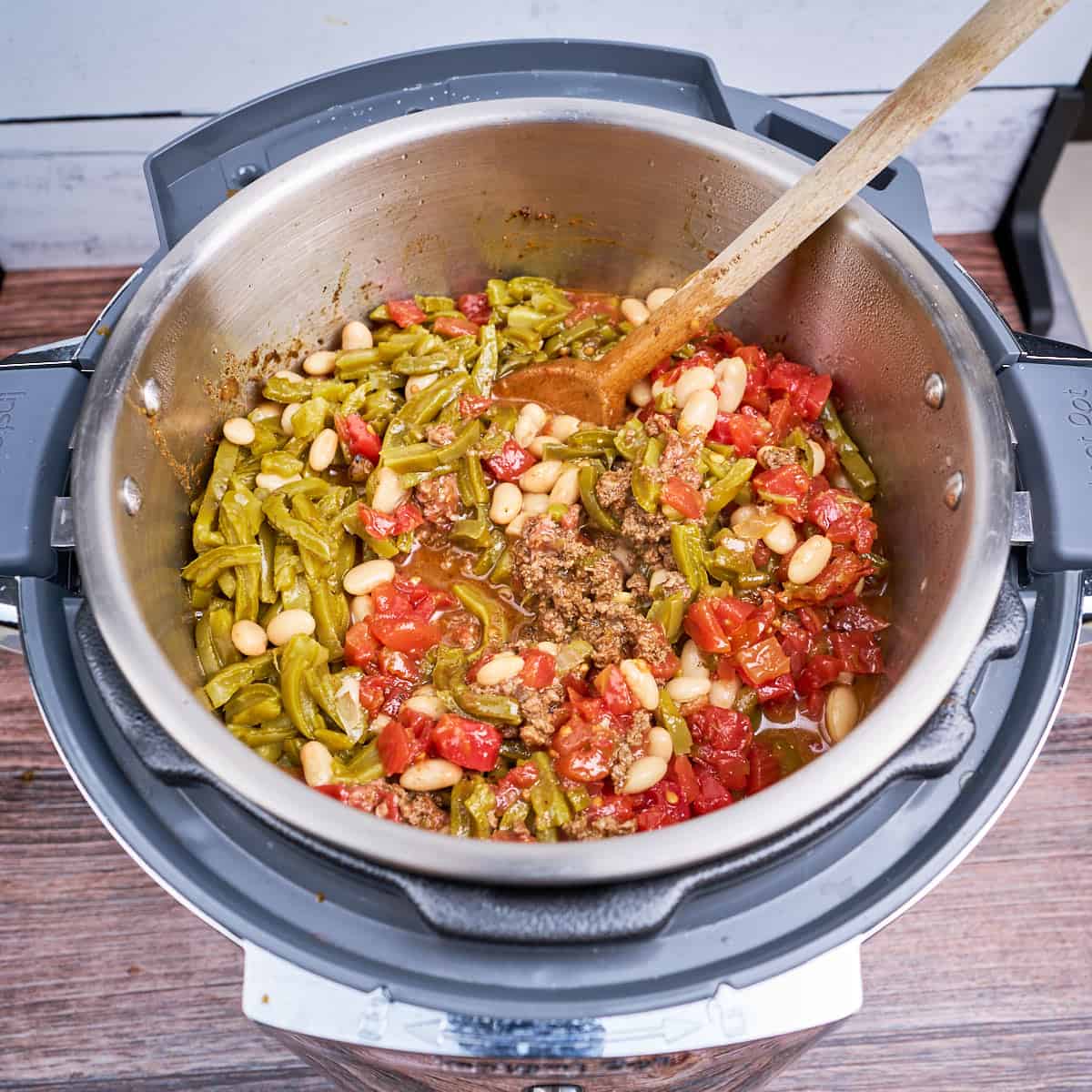 Cactus, beans, and tomatoes added to the pot