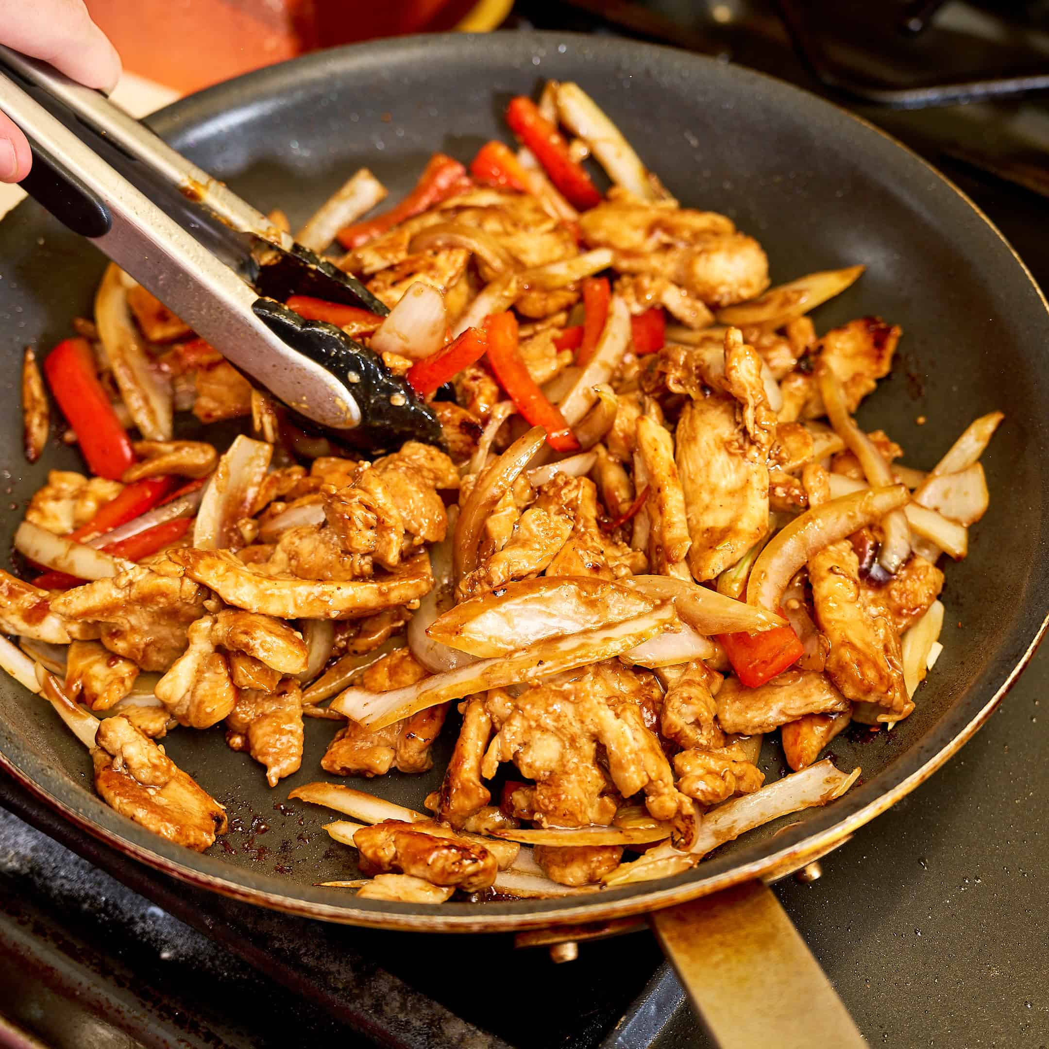 Tossing the stir fry to coat with hoisin sauce
