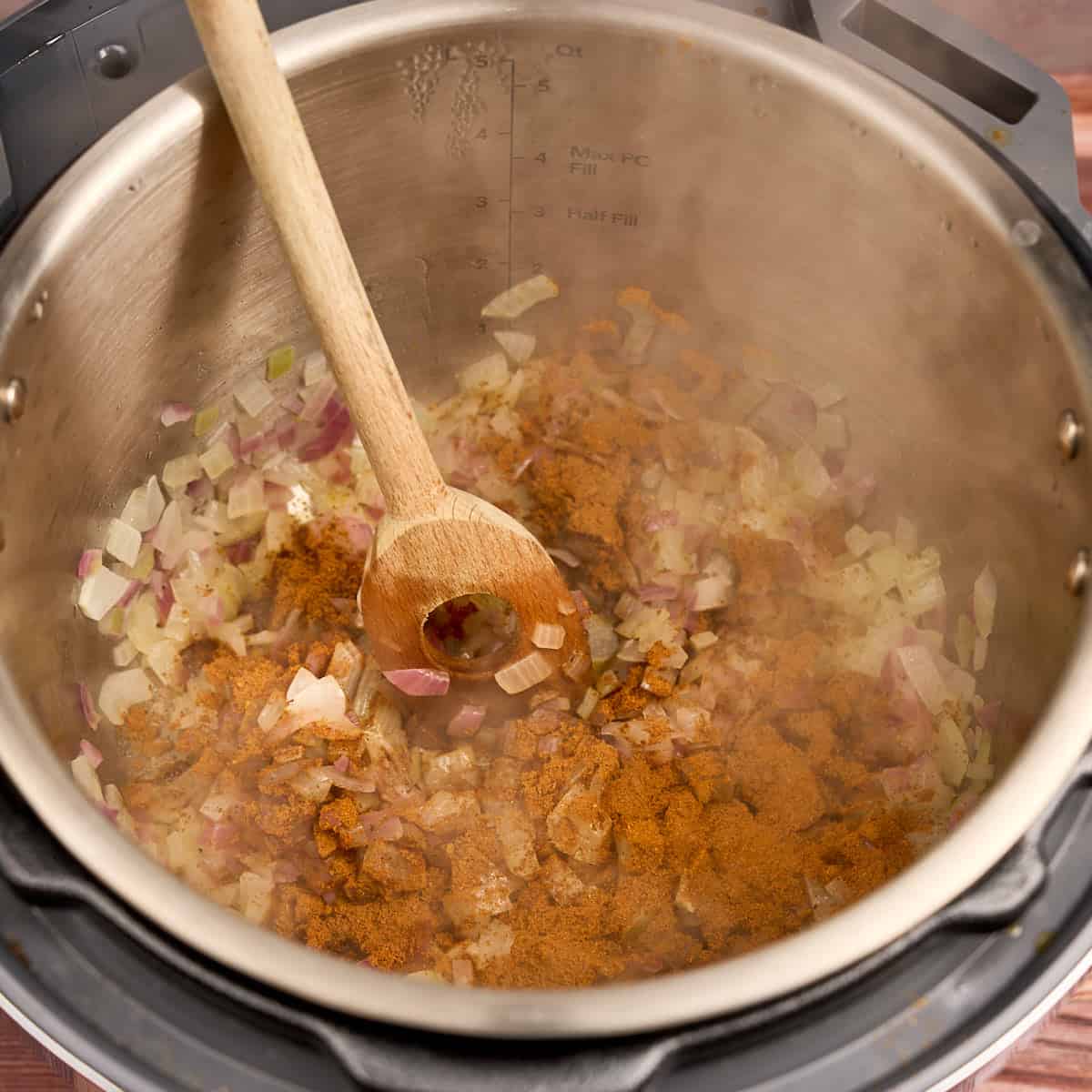 Adding the spices to the sauteed onion