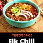A bowl of Instant Pot Elk Chili topped with cheese, green onions, and pickled jalapenos